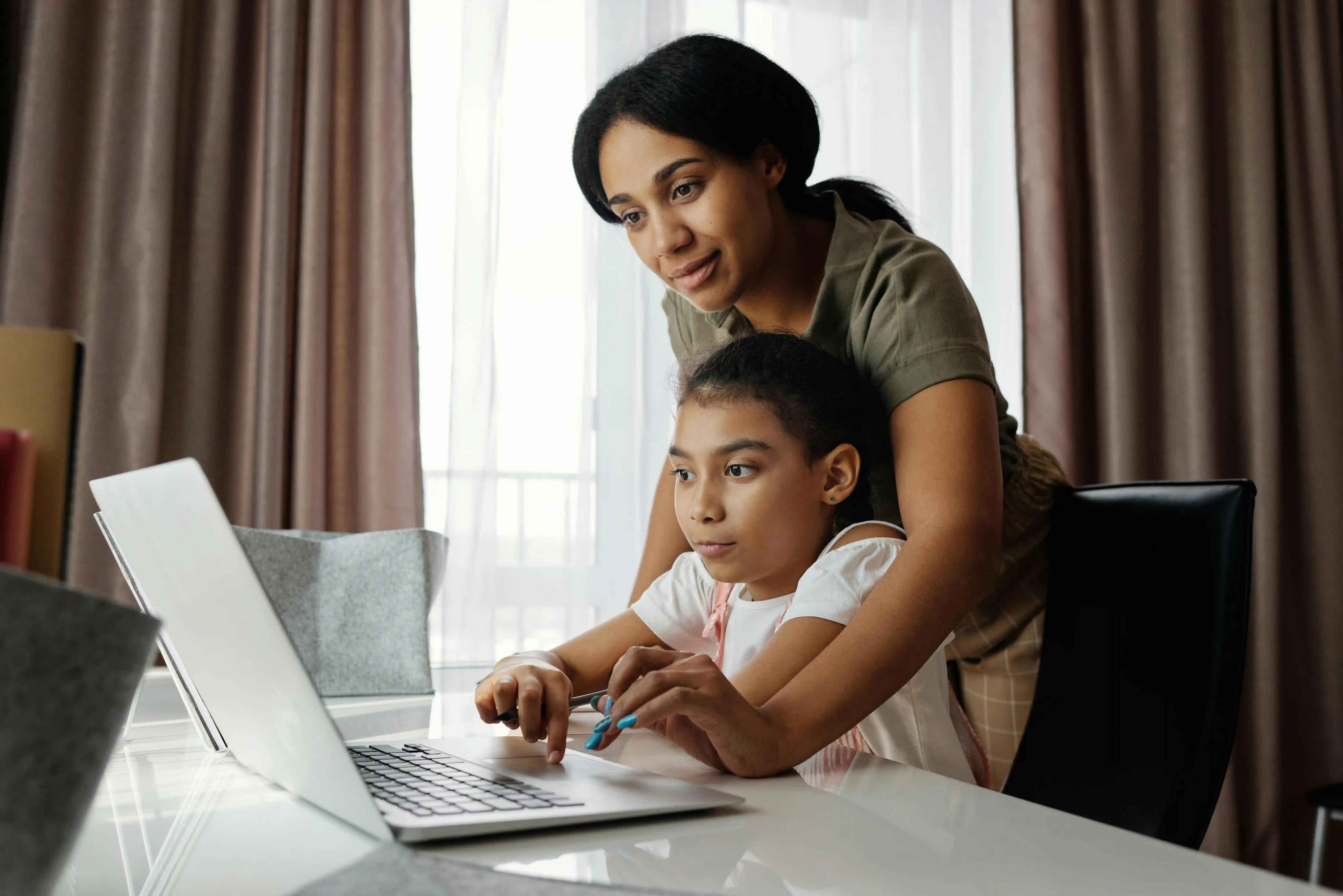 A parent supporting their child while they learn at home