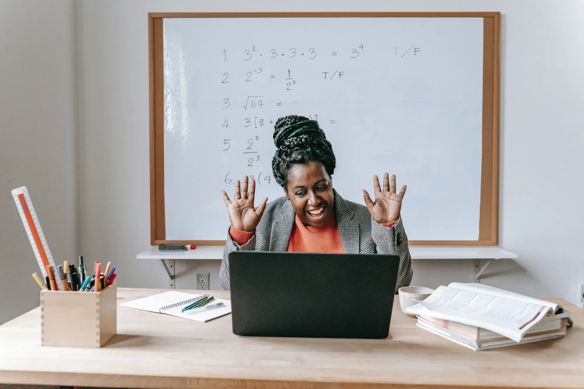 An experienced tutor teaching online in front of a classroom whiteboard